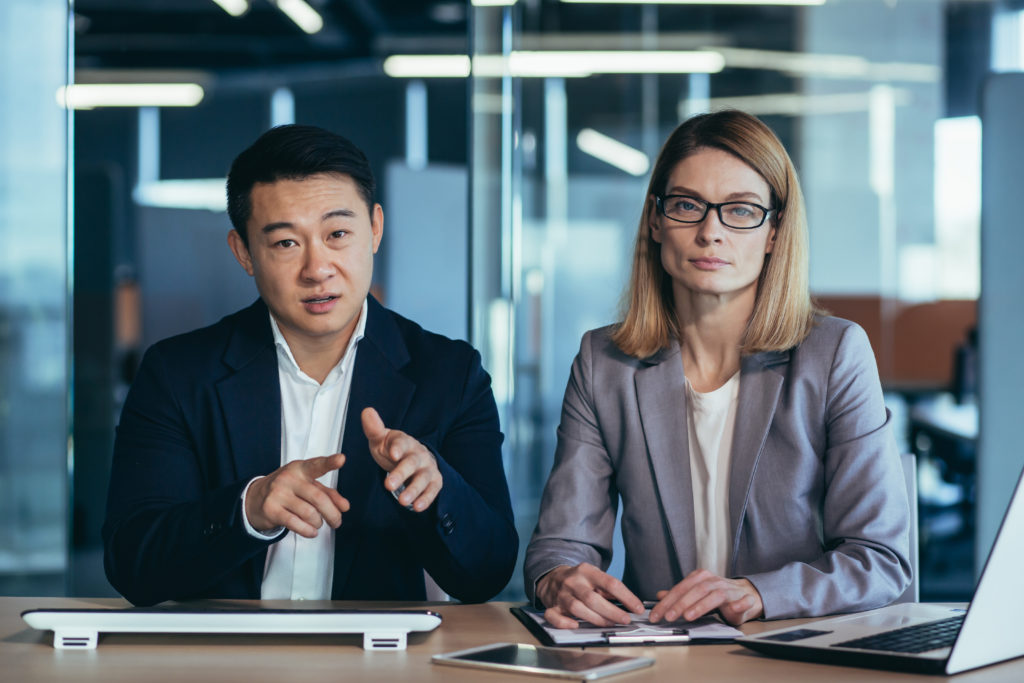 a team of business employees at an online meeting look at camera and communicate. Webcam view. conference remote interview. Two office workers talking Video call conversation. Asian male and female