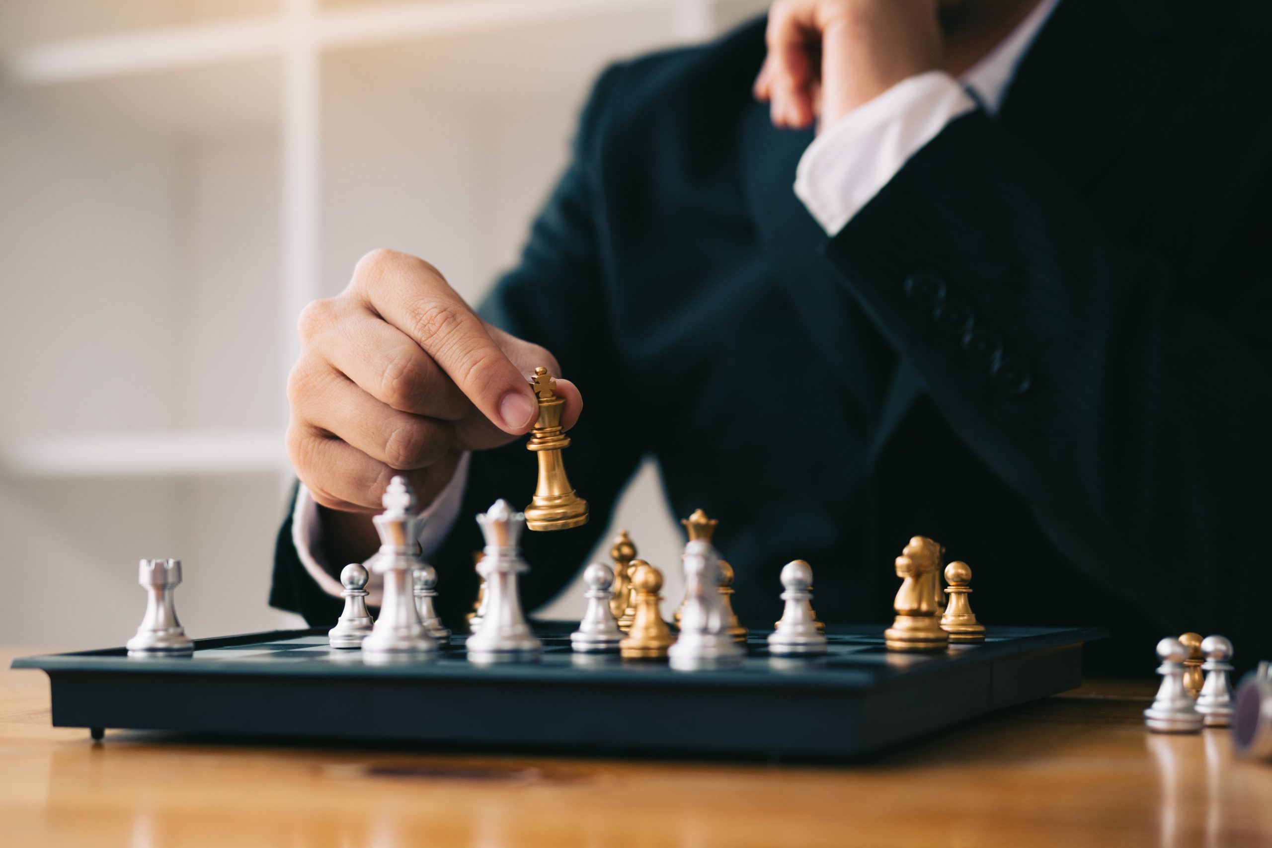 Businessman playing chess game beat opponent with strategy conce